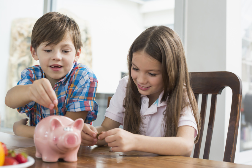 Kinder, die Geld in ein Sparschwein stecken